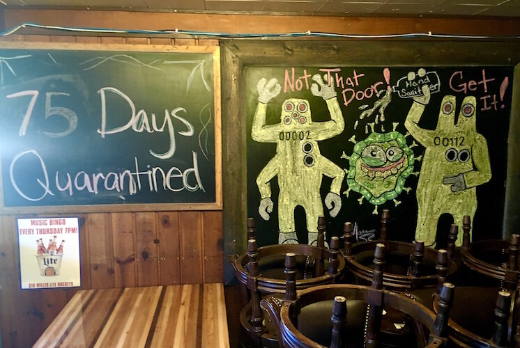 Some young customers used a large chalkboard at Louie’s Trophy House to draw monsters attacking a coronavirus molecule. Another board shows how long the place has been without sit-down service. (The count was through June  30).