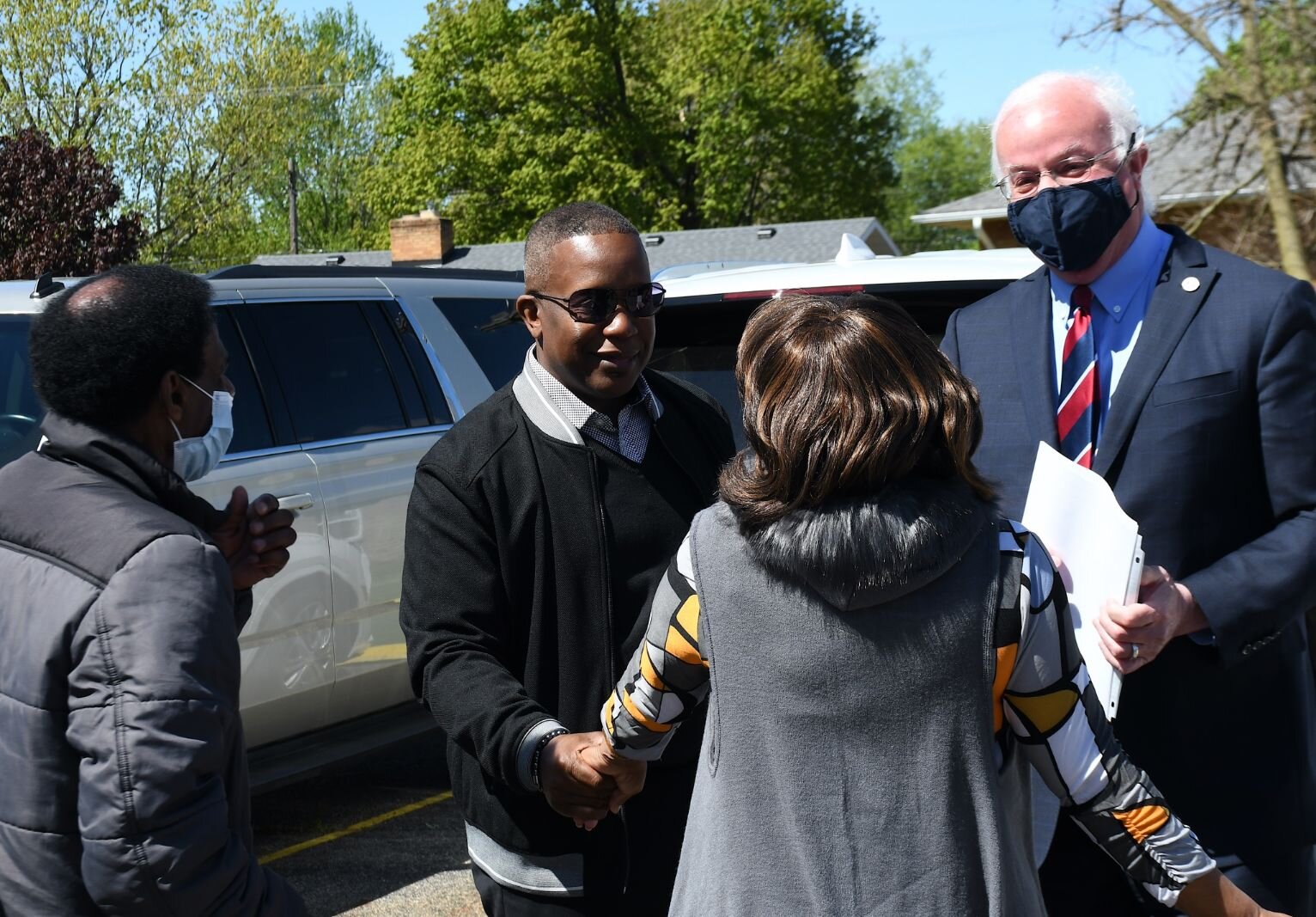 While Bobby Holley, left, looks on, Pastor Chris McCoy and Mayor Mark Behnke greet Maude Bristol-Perry.