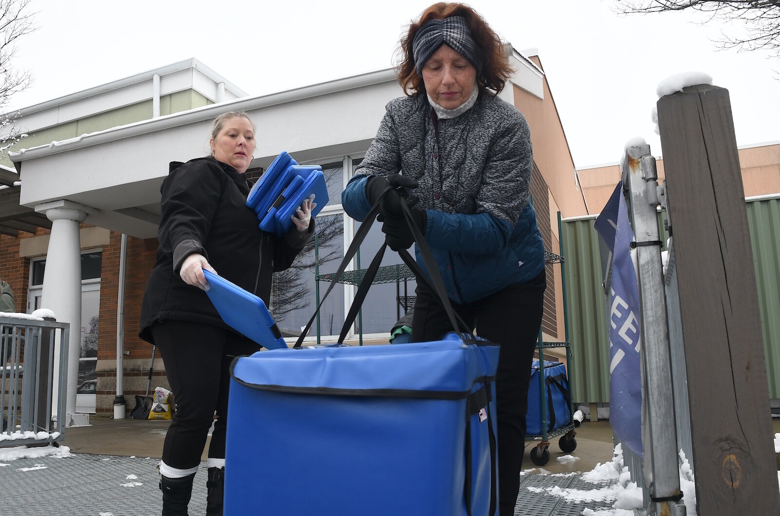 Karren Bartholomew-Scullion of Senior Services, left, brings a list of meal recipients to Theresa Burke, meals on wheels volunteer.