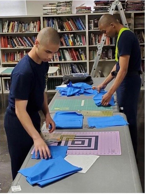Michigan Youth Challenge Academy Cadets Jonathan Ciszczon and Jonathan Shapiro measure and cut fabric to make cloth masks to be donated to facilities in the surrounding Battle Creek community on Wednesday, April 8