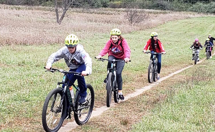 In a pre-COVID activity, Portage Central Middle School students learn Wearing a helmet, rules of the road, maintenance, basic pedaling as they improve their mental focus.