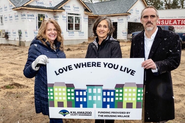 Kalamazoo County Housing Director Mary Balkema, left, stands with Portage Mayor Patricia Randall and Kalamazoo County Board Chairman John Taylor in front of a multi-unit project in Portage that is receiving money from the county’s new house in millag