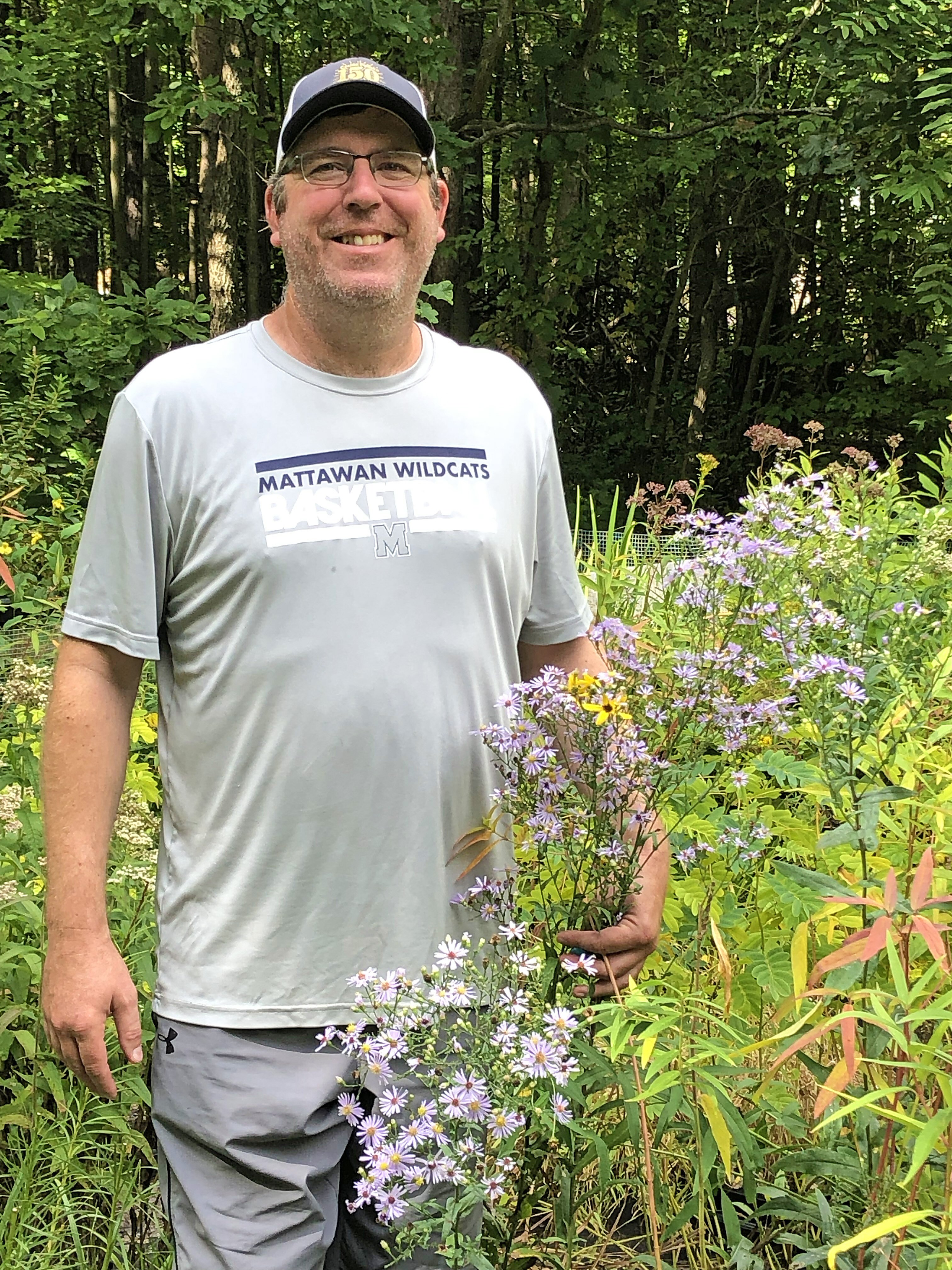 Chad Hughson, owner of Hidden Savanna Nursery, holds an aster.