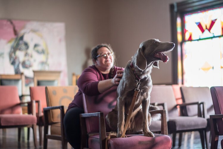 Adrienne Waller takes a moment to play with Stephen Dupuie’s dog “Finnegan” inside The Dormouse Threatre.