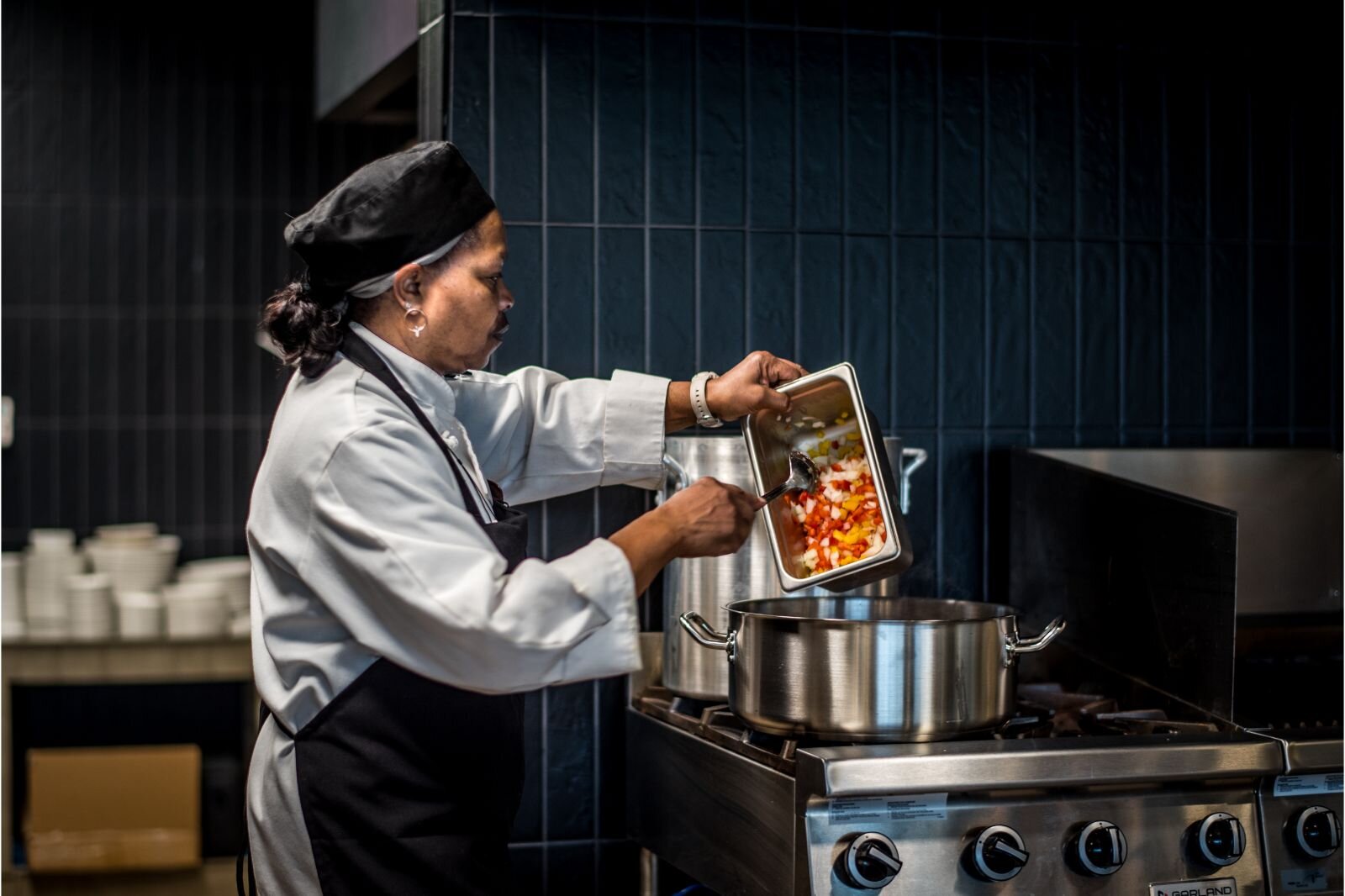 Sous Chef Lorain Langston prepares spaghetti for an evening meal in one of two indoor eateries at the new Revel Creek independent living community for older adults.