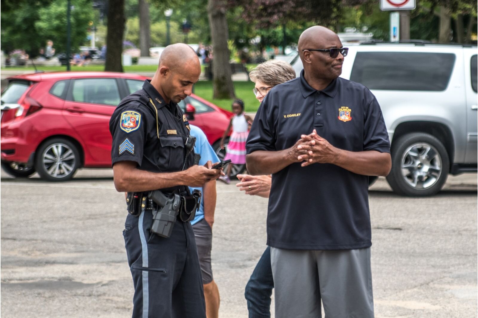 Kalamazoo Department of Safety Chief Vernon Coakley watches the children enjoying the Children's Nature Playscape along with Sgt. Andrew Werkema, head of the Community Policing Unit.