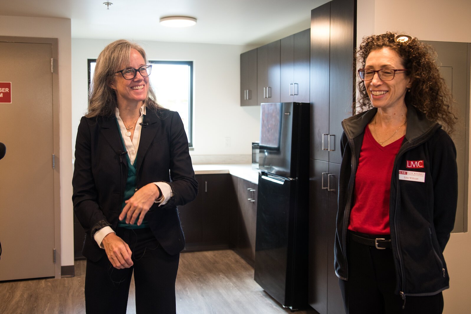 Carole McNees, left, is president of the LIFT Foundation Board of Directors. She is shown speaking with Lisa Willcutt, who is principal at Lockhart Management & Consulting LLC, the firm contracted to oversee the management of the new apartment house.