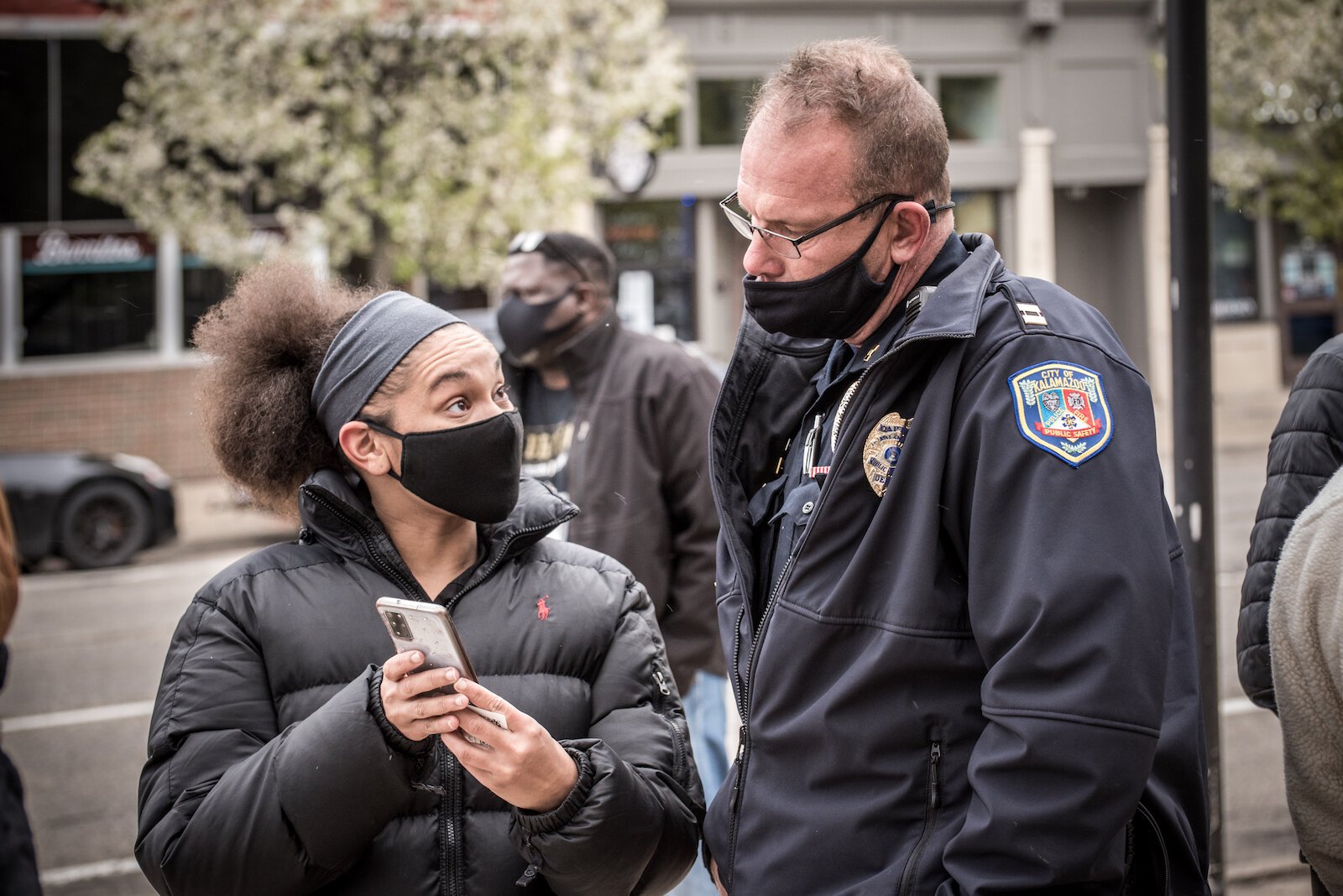 Capt. Matt Elzinga, of the Kalamazoo Department of Public Safety, speaks with a woman Tuesday outside the Kalamazoo County Courthouse.