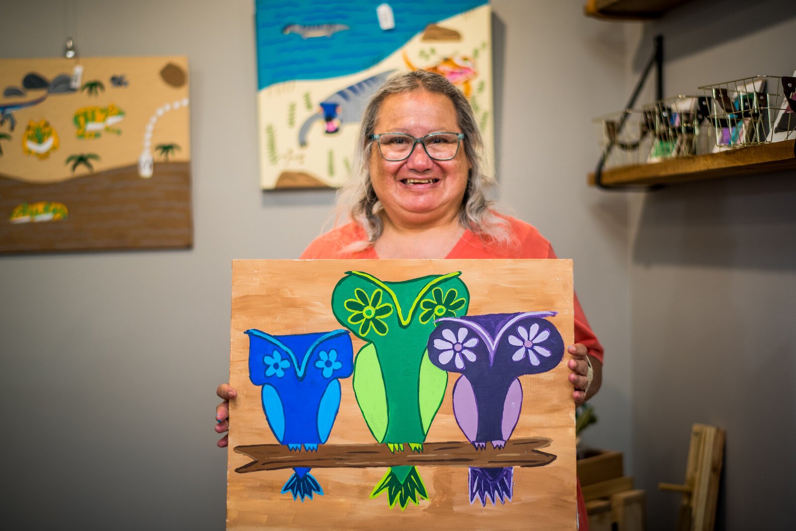 Joan Ruiz, artWorks' artist, displays some of her painted owls.