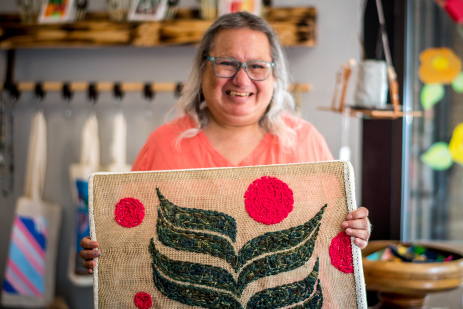 Artist Joan Ruiz with a wall-hanging she created.