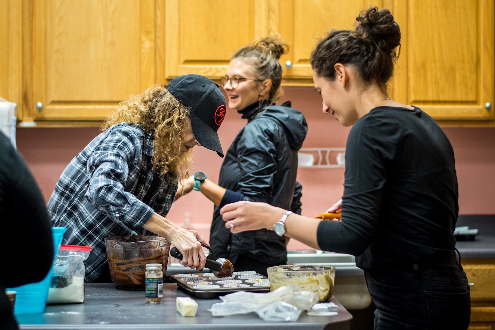 Nicole Thompson of United for Unsheltered, in ball cap, works with others to make food and assemble care packages for Kalamazoo's homeless.