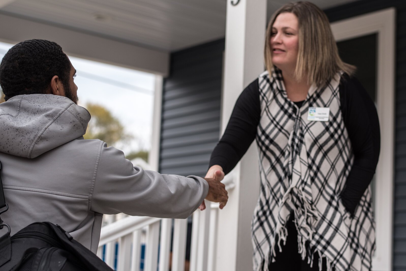 Dara Smith, neighborhood services specialist with KNHS, greets visitors at the unveiling on Tuesday, Oct. 25, 2022, of a new duplex at 203-205 Wall Street in Kalamazoo’s Vine Neighborhood.