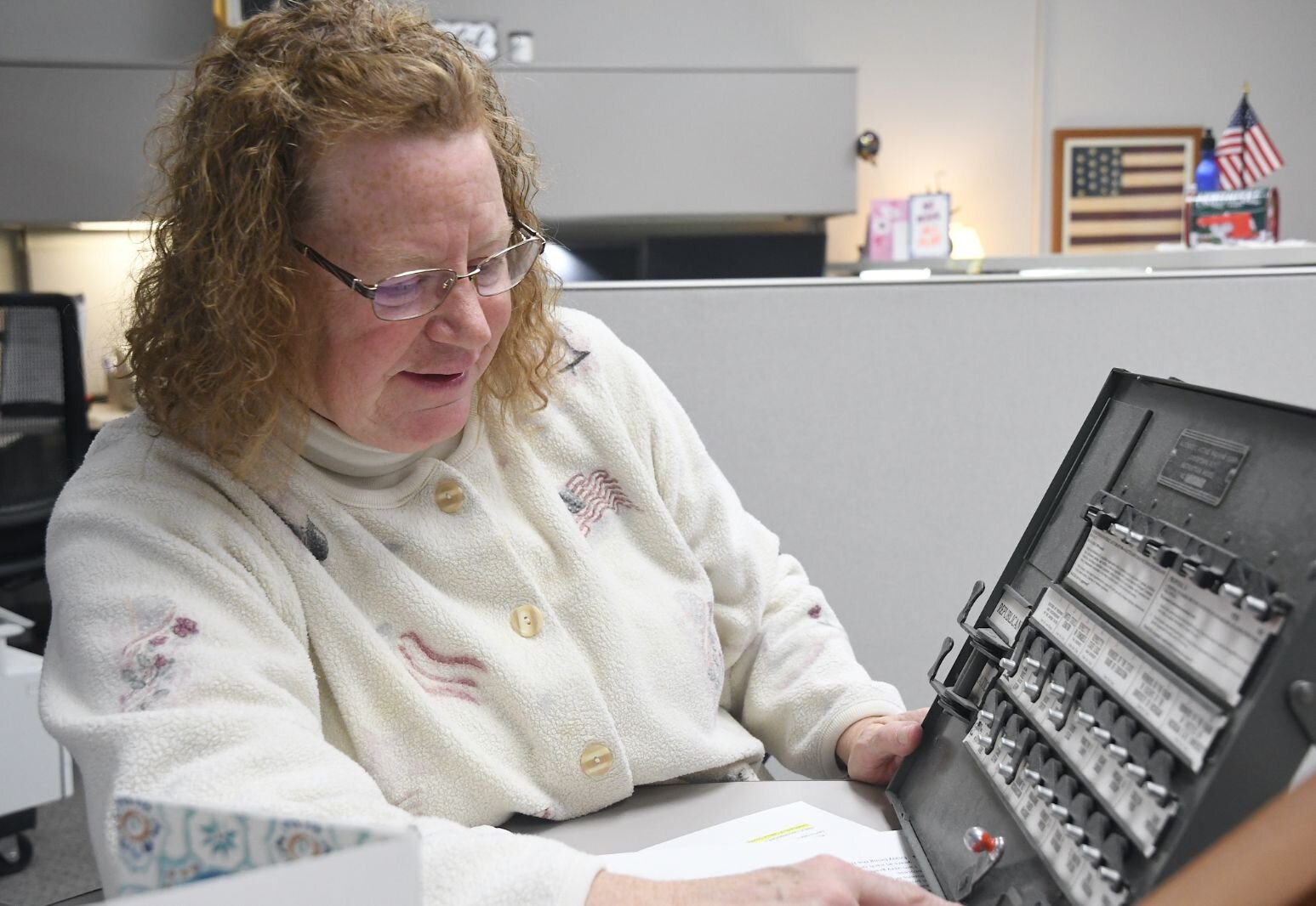 Teri Loew, Chief Deputy Clerk of Elections for Calhoun County, shows a lever machine that formerly was used to cast a ballot.