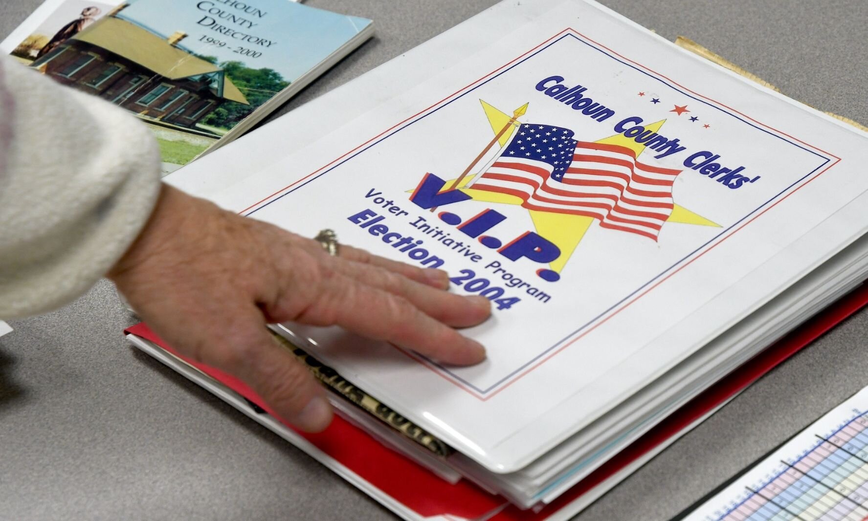 Teri Loew points out a book prepared for the 2004 Voter Initiative Program.