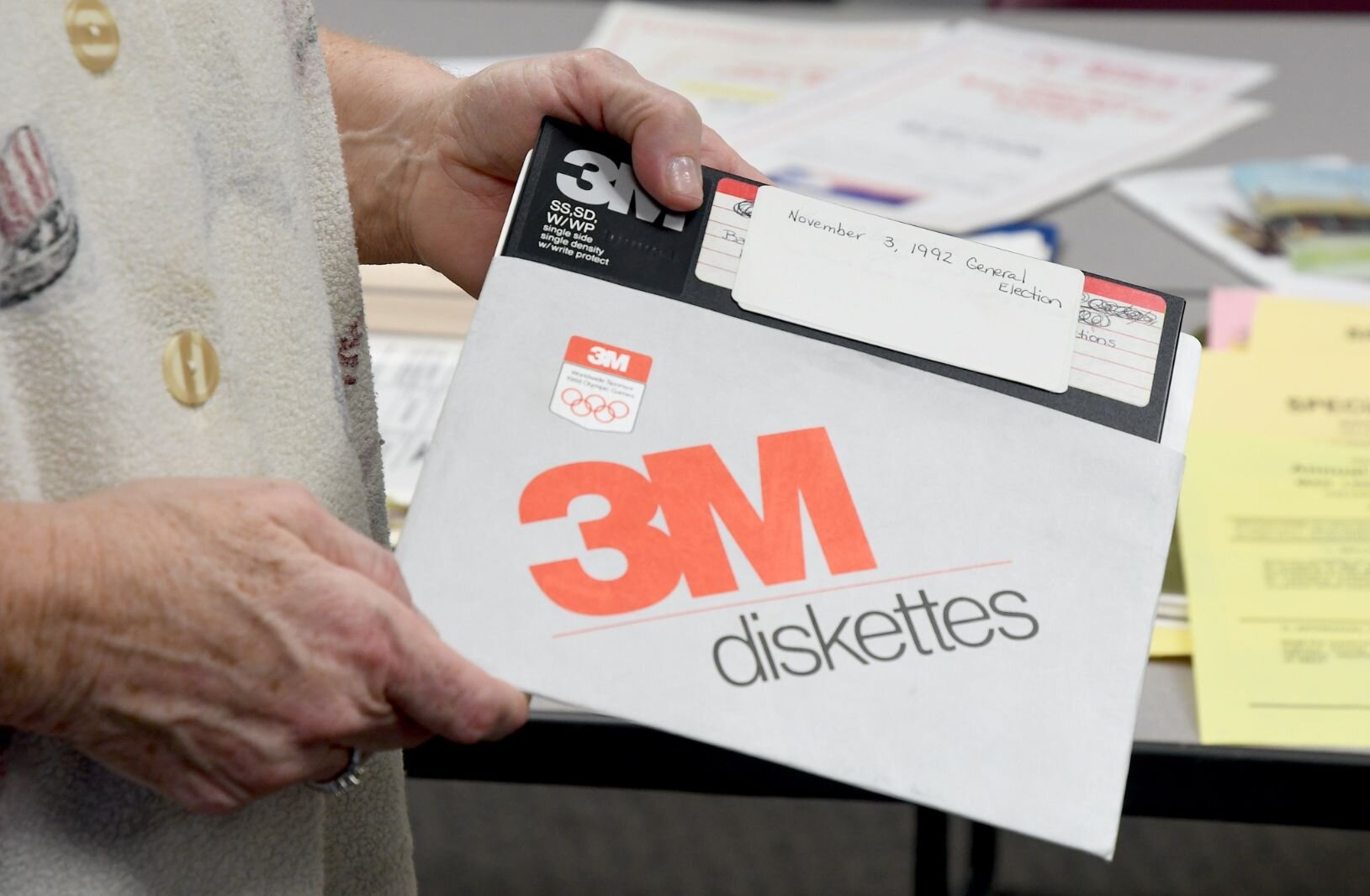 Teri Loew holds a 8-inch floppy disk used as a backup for data in the 1992 general election.