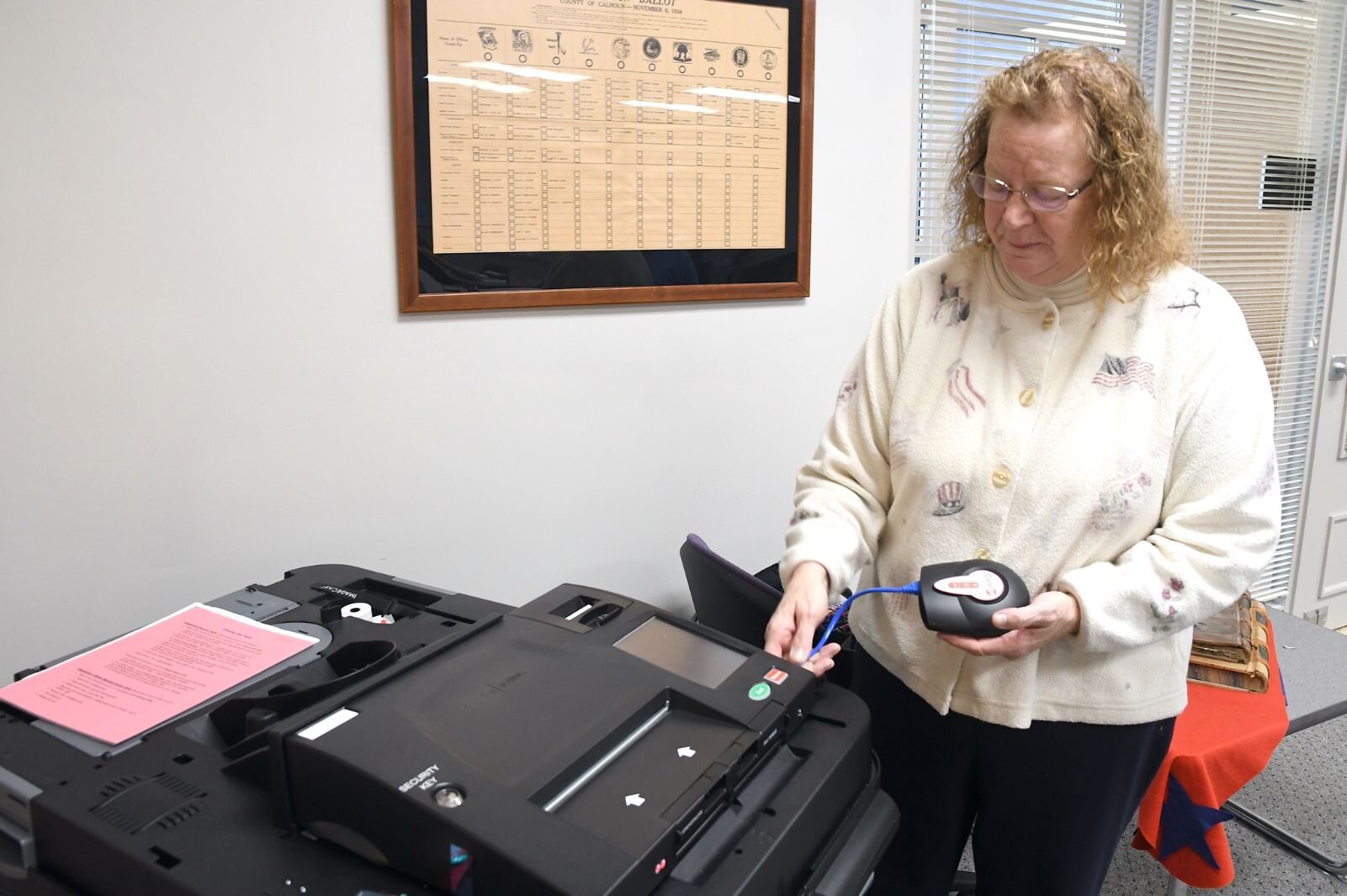 Teri Loew, Chief Deputy Clerk of Elections for Calhoun County, demonstrates some of the workings of a current ballot tabulating machine.