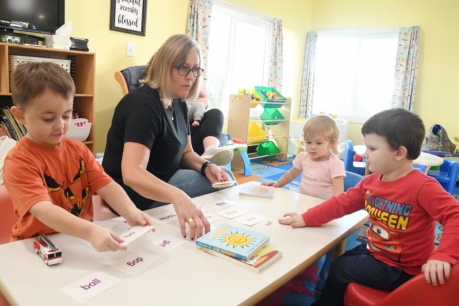 Stacey Olsen works with, from left, Jaxon Meek, Riley Furguson, and Jameson Eickhoff at Rose of Sharon Child Development Center.