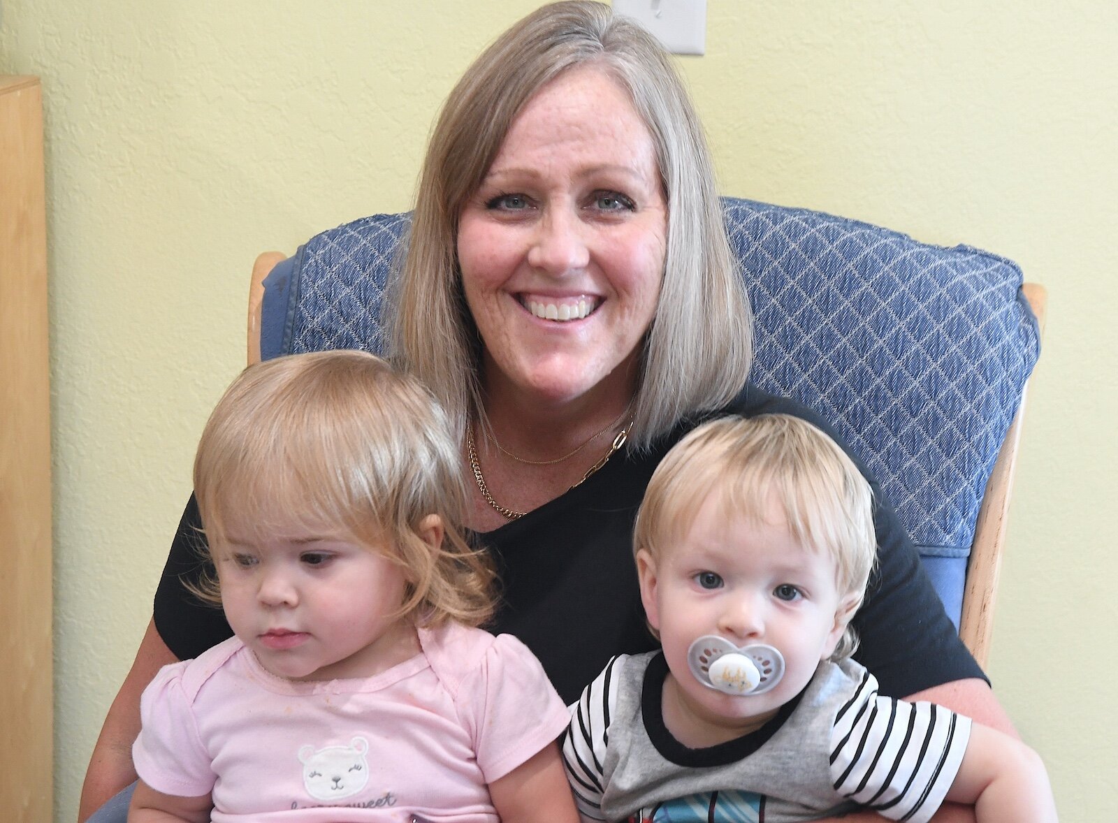 Stacey Olsen holds, from left, Riley Furguson and Cade Juday.