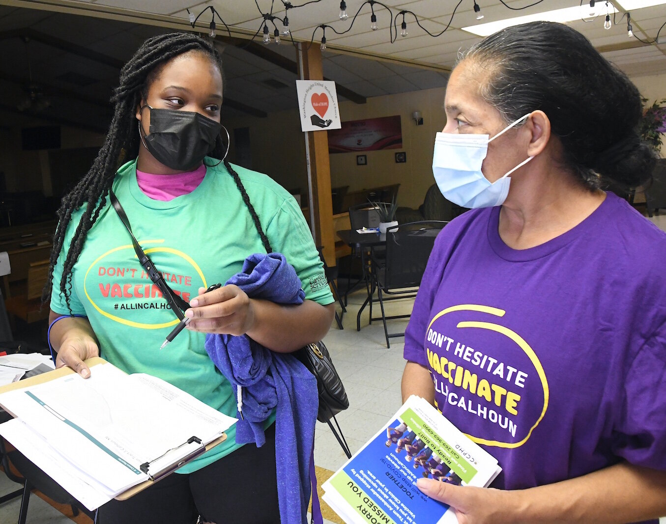 COVID Vaccine Ambassadors, from left, Lydia Campbell and Brittany Johnson walk on College Street as they go door to door encouraging people to get vaccinated. 