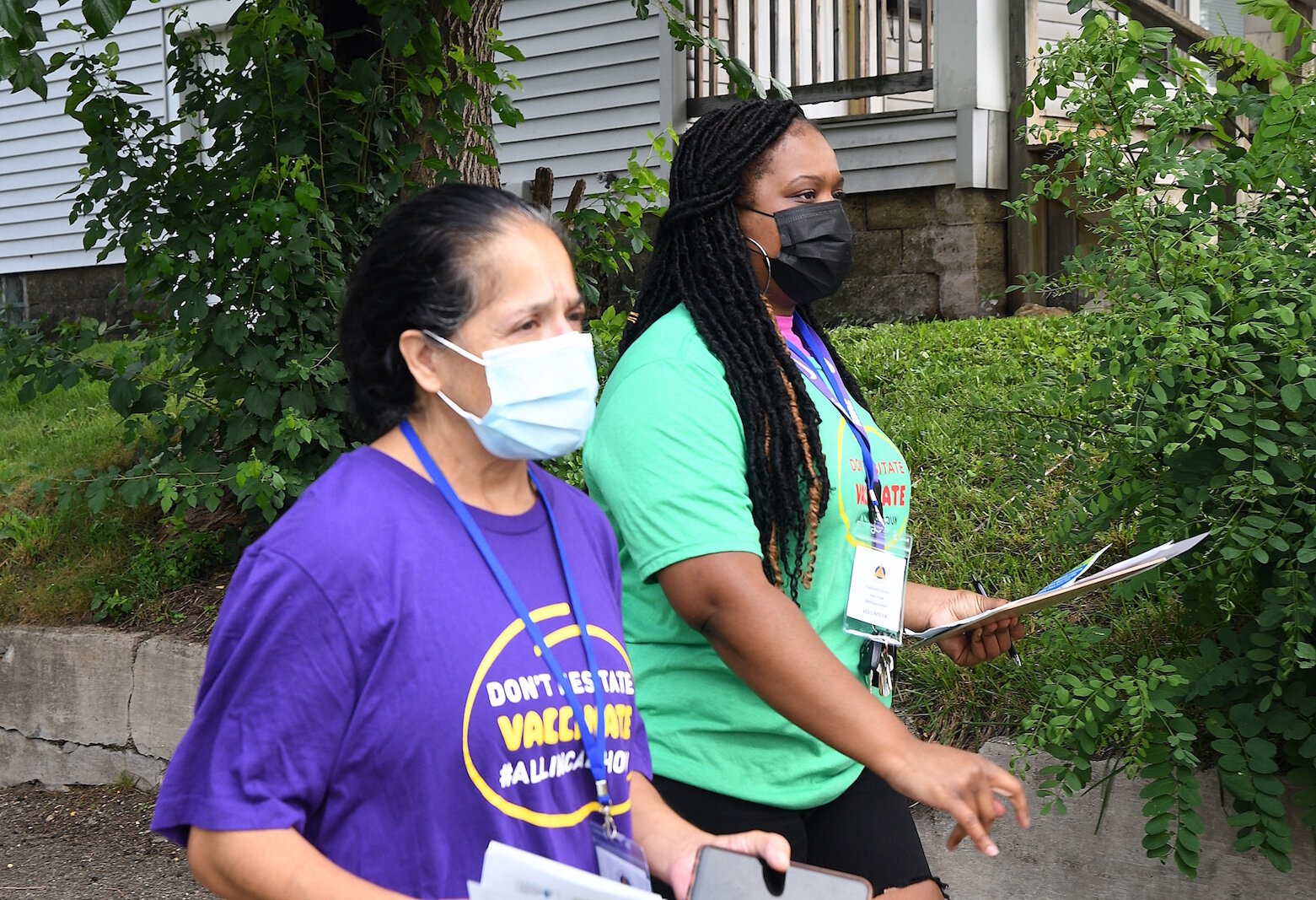 COVID Vaccine Ambassadors, from left, Lydia Campbell and Brittany Johnson walk on Eagle Street as they go door to door encouraging people to get vaccinated. 