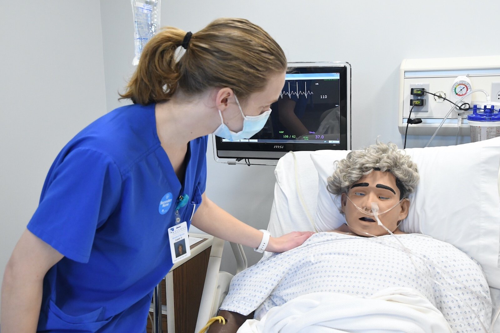 Caleb Vander Weide, a Kellogg Community College (KCC) nursing student, checks on “patient” Amado Rojos in the college’s sim lab.