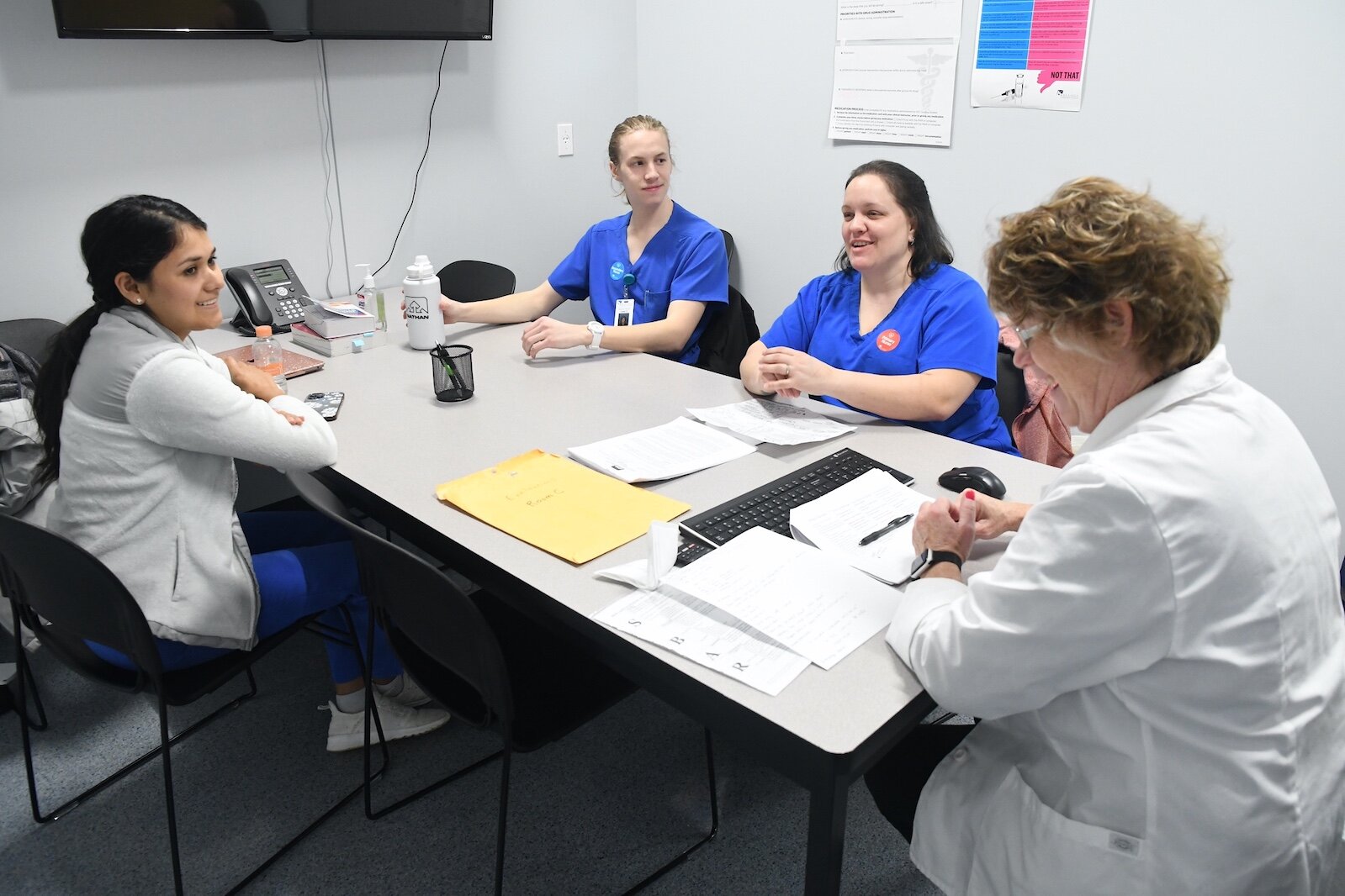 Renee Mielke, Ed.D., KCC nursing professor, meets with students about their treatment of a patient.