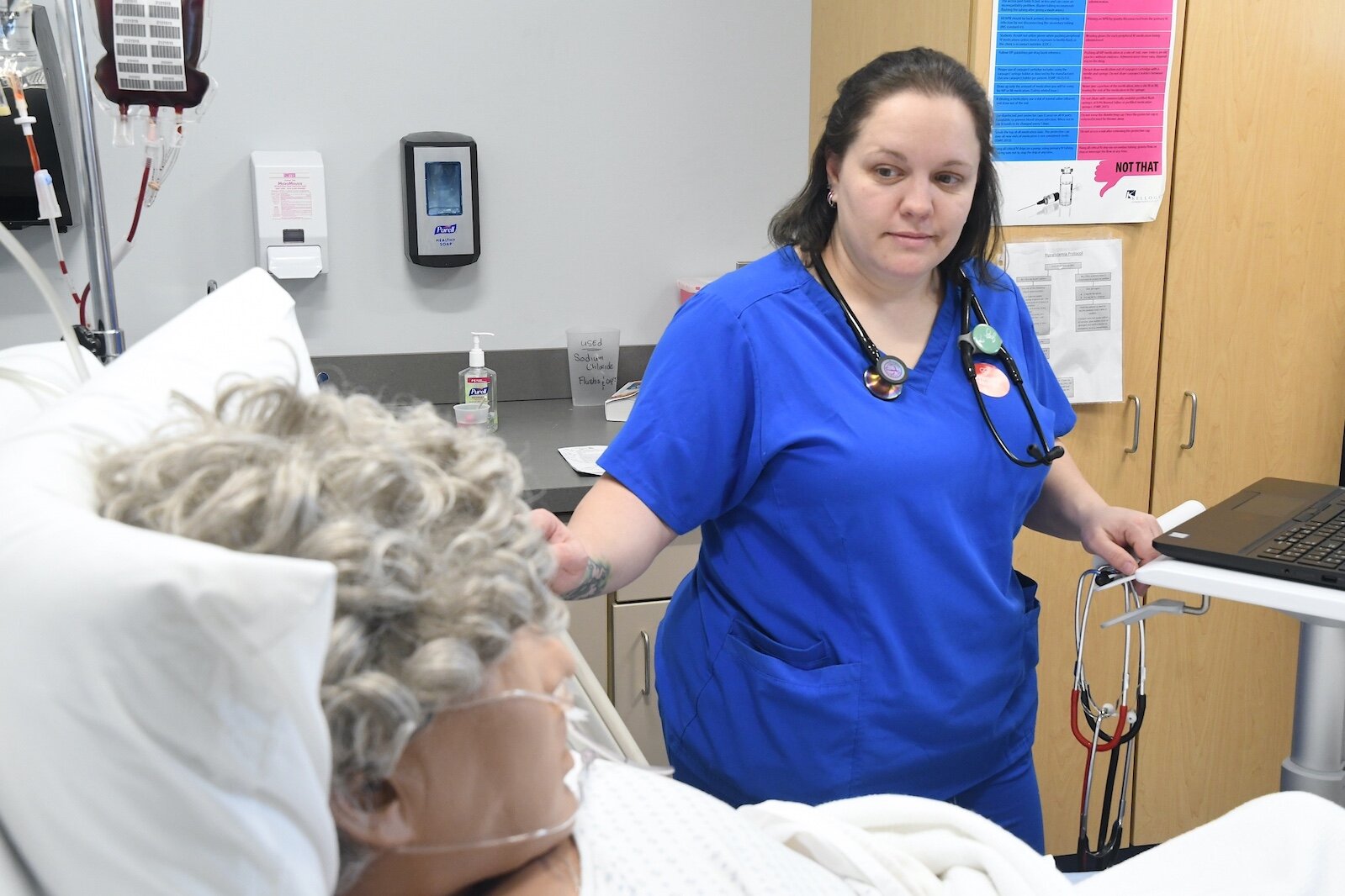 Jenny Tice, a Kellogg Community College nursing student, observes “patient” Amado Rojos in the college’s sim lab.