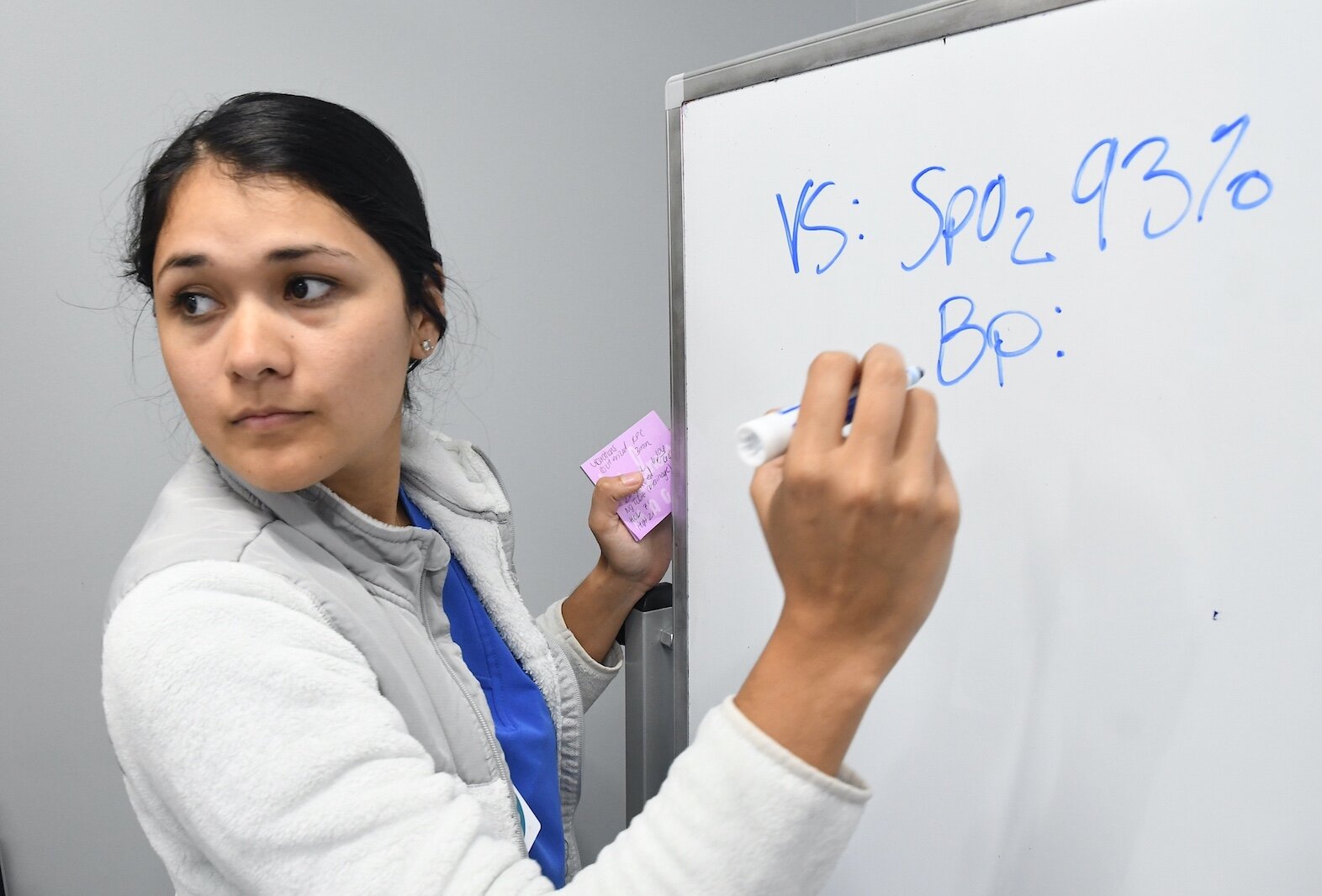 Vania Martinez, a Kellogg Community College nursing student, prepares to write down a patient’s vitals in the college’s sim lab.