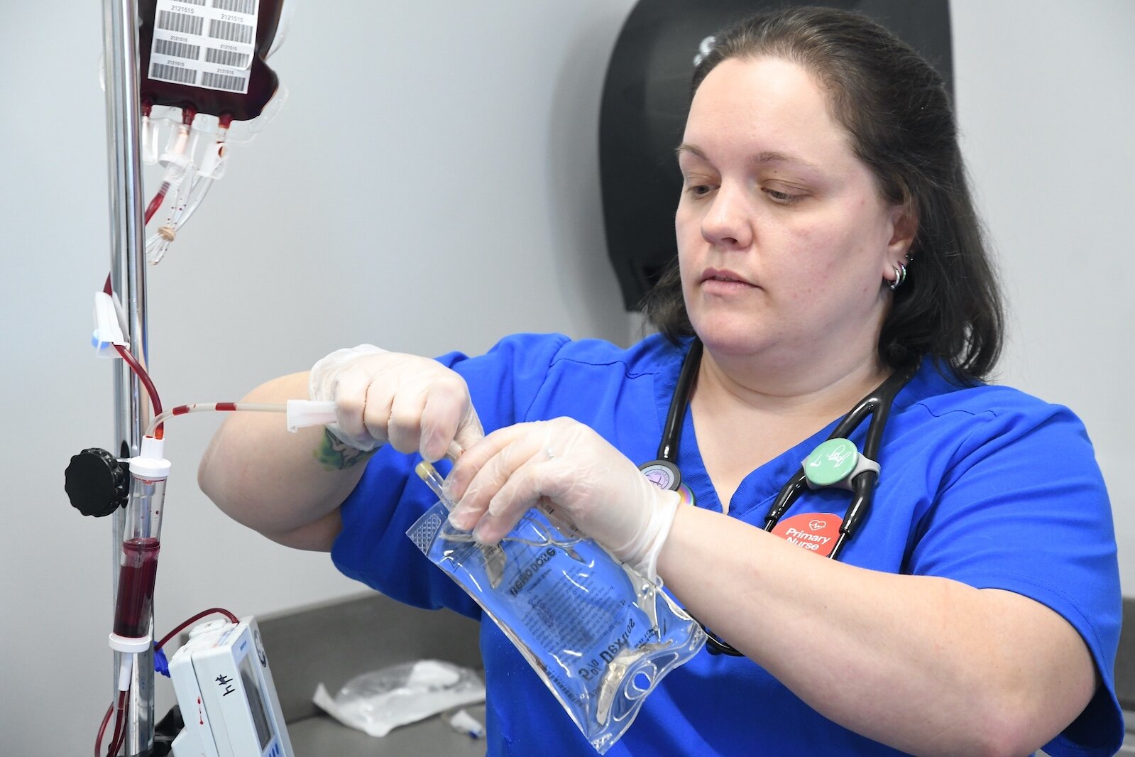 Jenny Tice, a Kellogg Community College nursing student, adjusts an IV bag for “patient” Amado Rojos in the college’s sim lab.