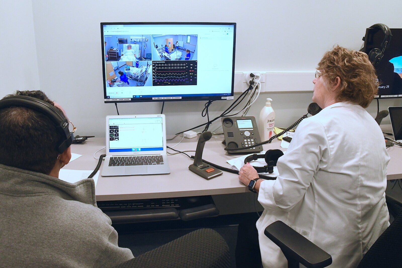 Rico Earl, simulation coordinator, left, and Renee Mielke, Ed.D., nursing professor, observe KCC nursing students treating a patient in the college’s sim lab.