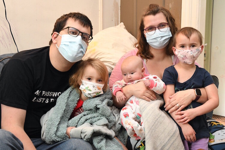 Fred and Chelsea Potier and their daughters, from left, Melina, Margaux, and Aveline sit In the living room of their home on Fremont Street. Their 105-year old home recently was updated to remove lead, including painting and window replacement.