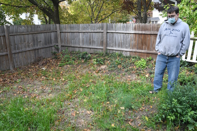 Fred Potier stands in the backyard of his family home where some tilling and landscaping was done during recent lead abatement work.
