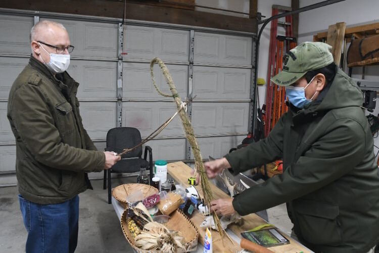 John Rodwan, Environmental Director, left, and Doug Taylor, Historic Preservation Officer, demonstrate how wild rice is harvested near the Pine Creek Reservation.