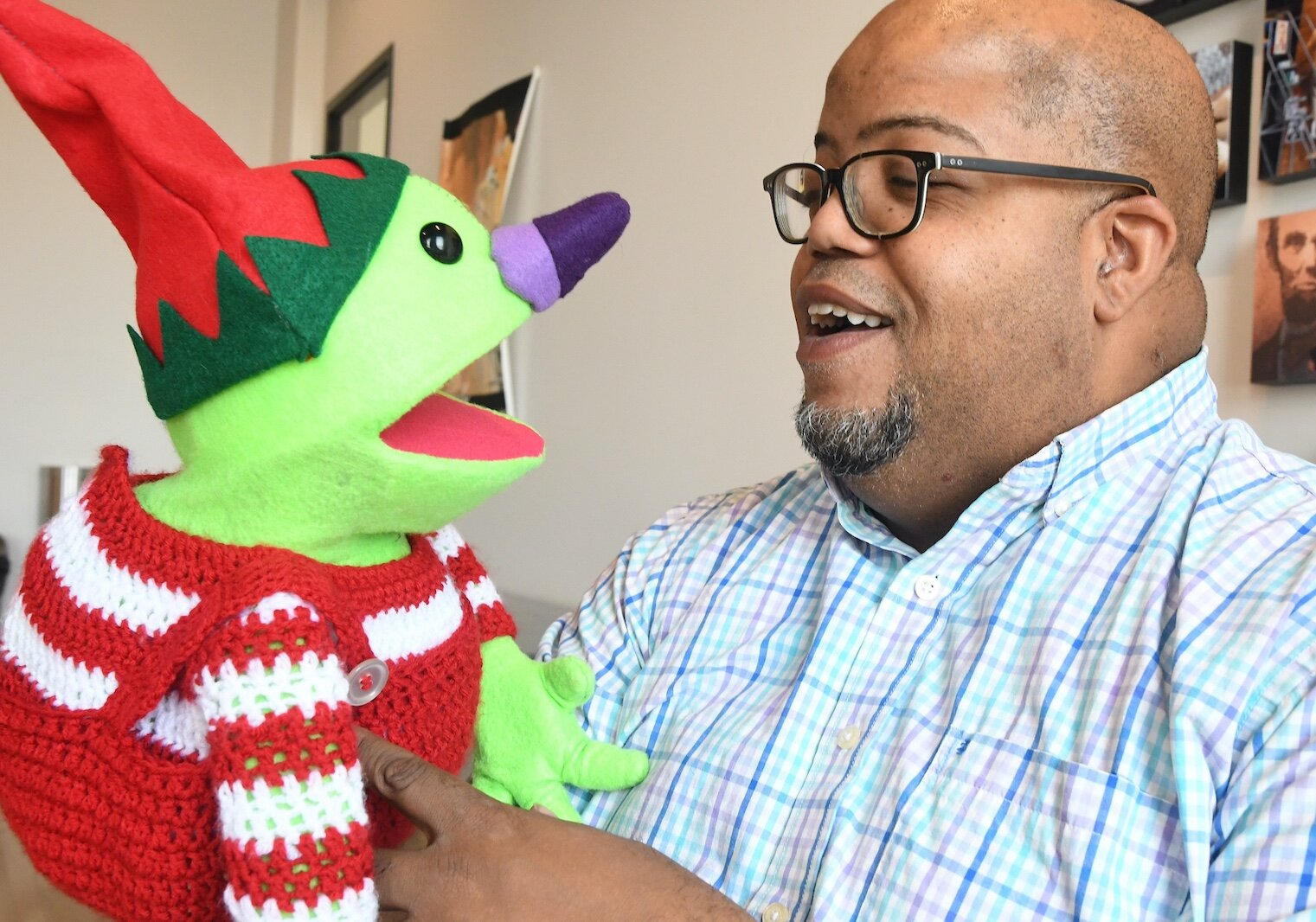 Clovis Bordeaux smiles as he holds Dippy, one of his puppets.