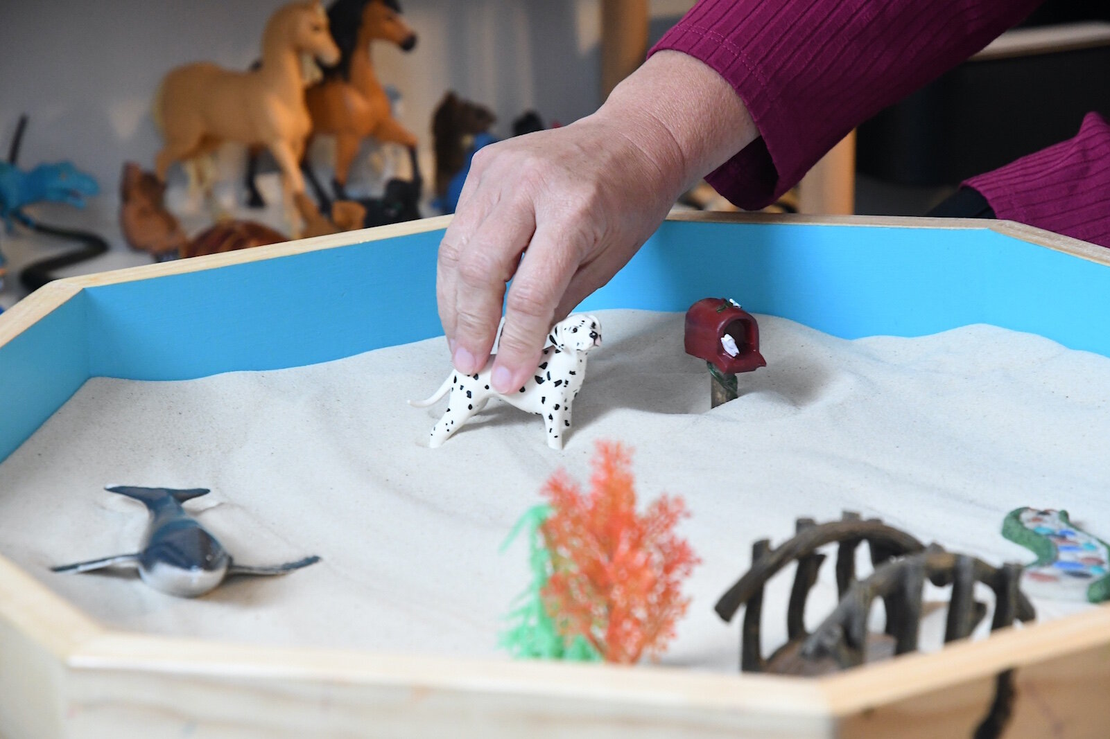 Sherrie Schanzenbaker places an item in the sand tray at the Restoration Center