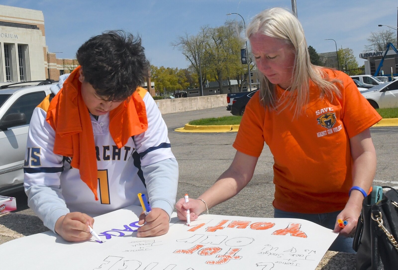 People prepare signs before an organizer of an anti-gun violence march and rally in downtown Battle Creek.