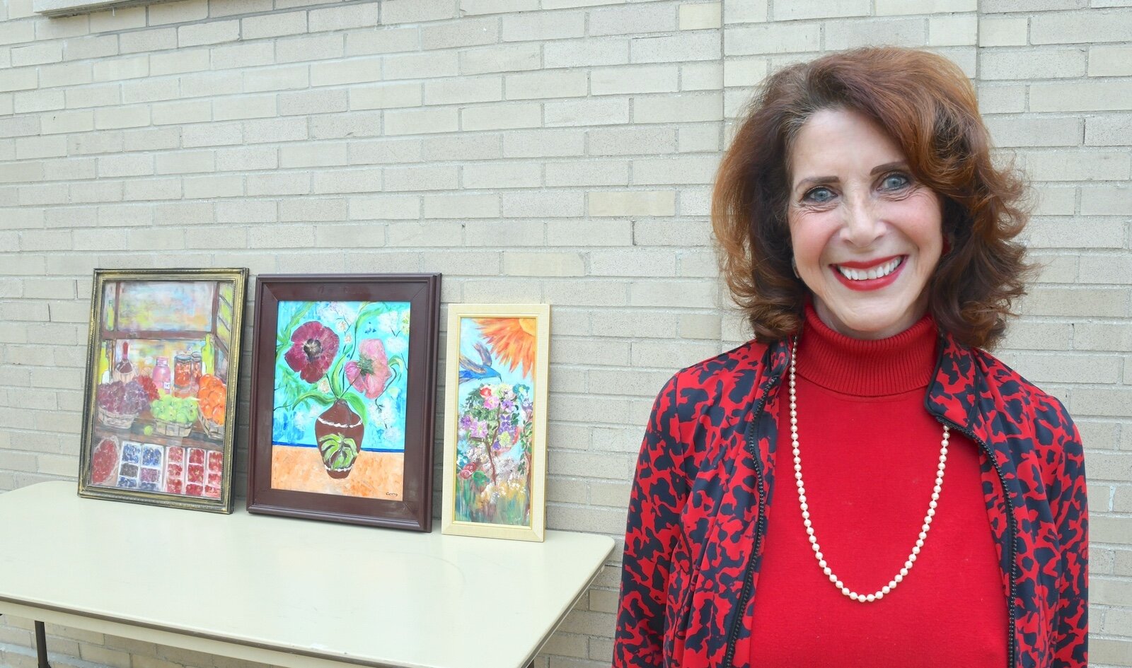 Coco Sweezy is seen with some of her paintings.