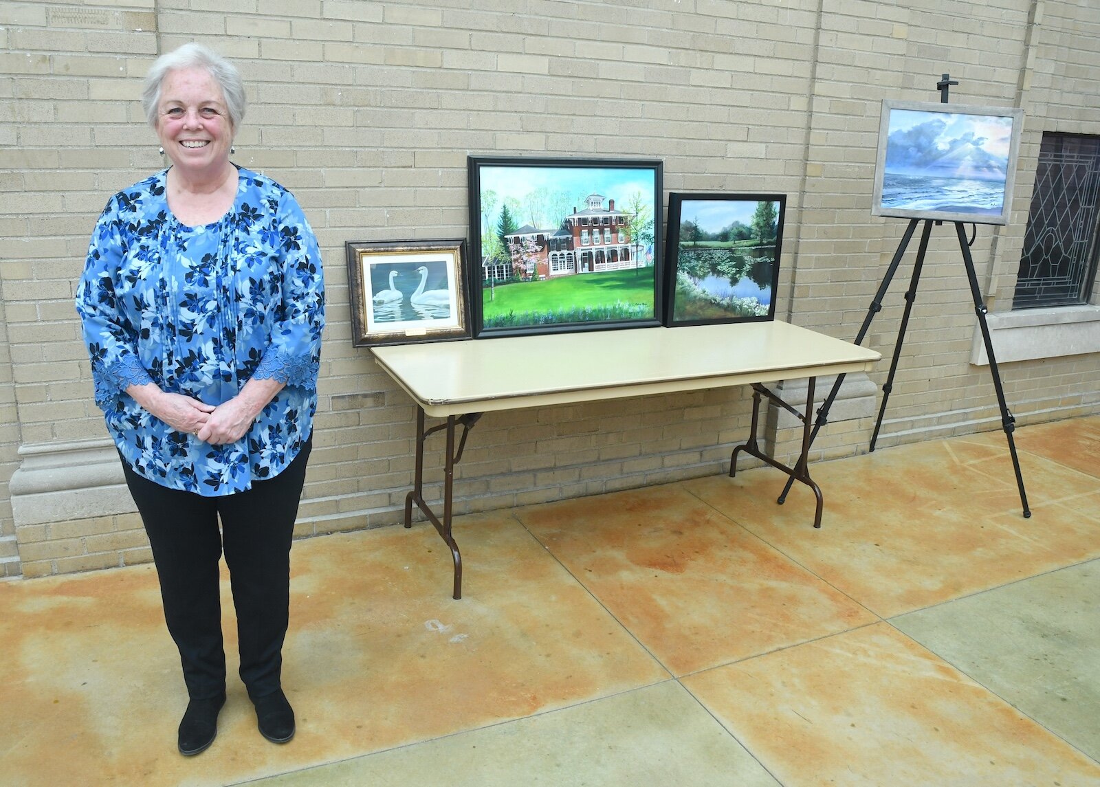 Melanie Wheeler is seen with some of her paintings.