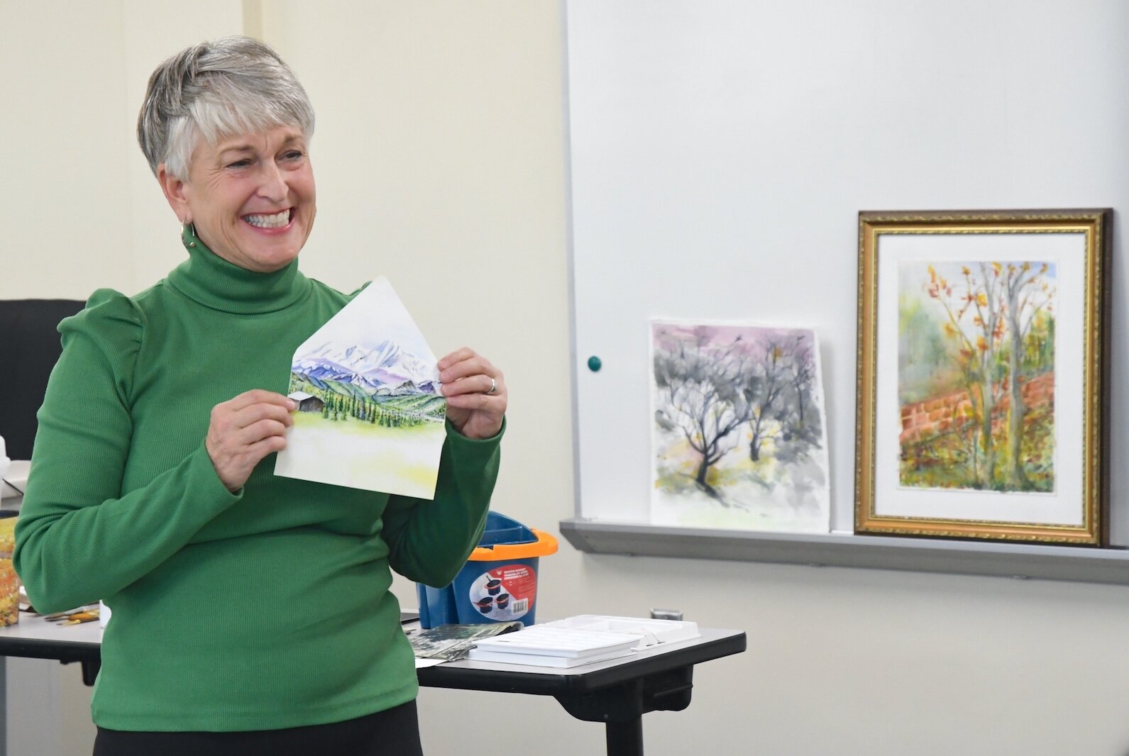 Liz Sweeney shows a painting to students during a Lifelong Learning waterclass class.