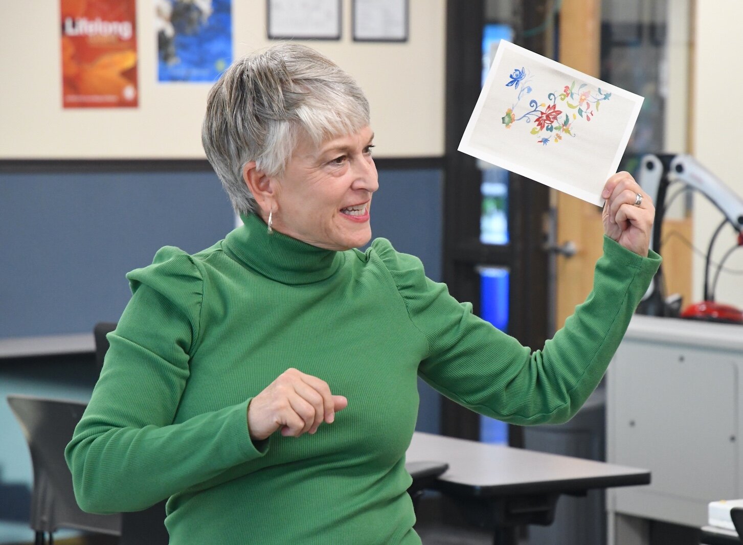 Liz Sweeney shows a painting to students during a Lifelong Learning waterclass class.