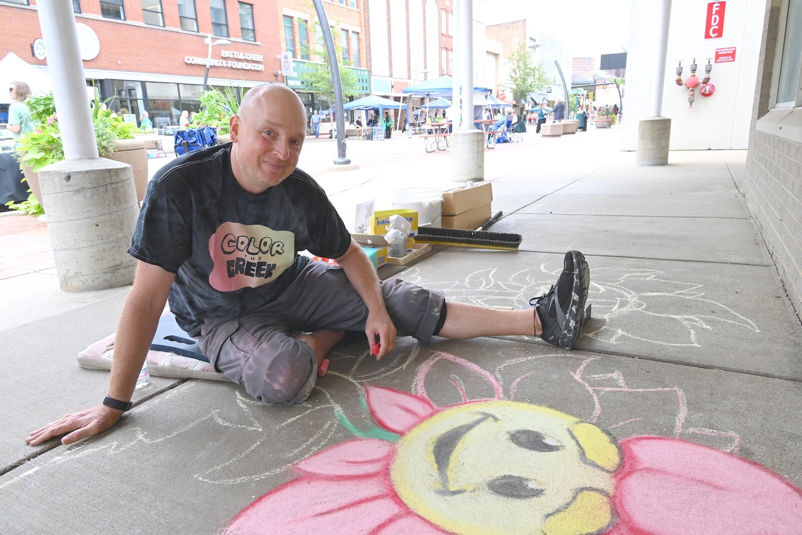 Garald Barton IV of Color the Creek works on chalk painting at the BCCF’s block party.
