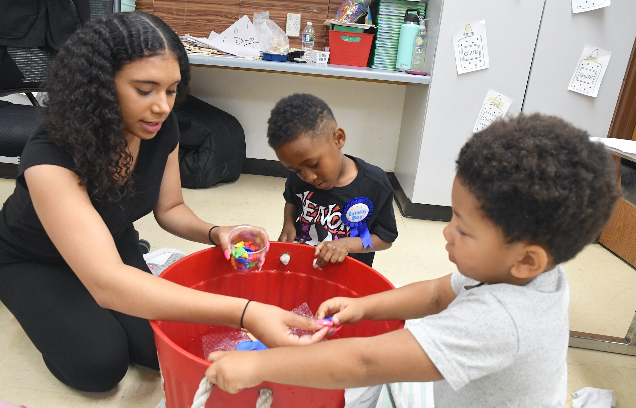 Sadaiza Hough, left, helps Bakari Wilson, center, and Tyshawn Wingfield with their boats during a morning session at Franklin-Post Elementary School.
