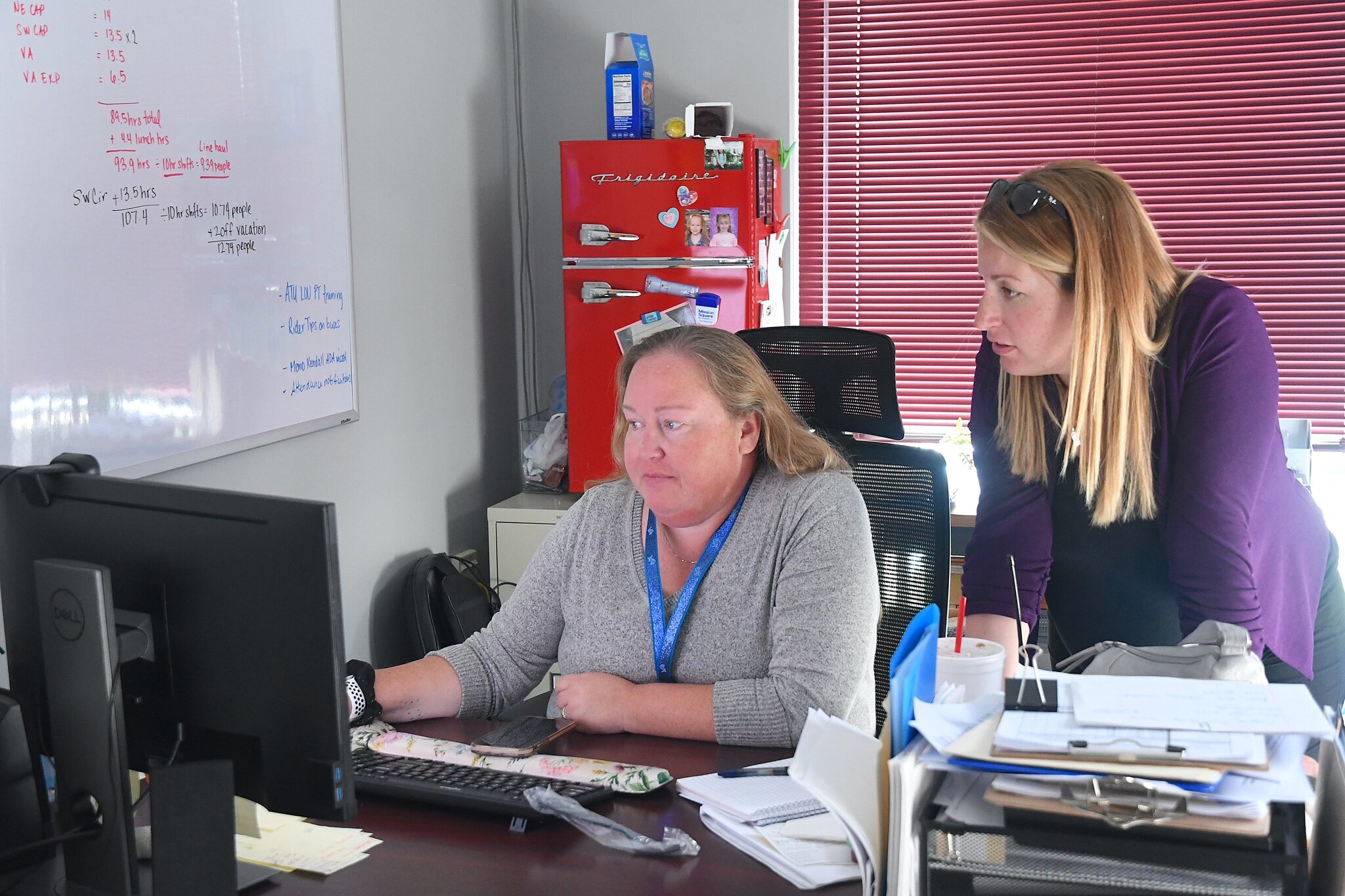 Shannon Wedl, Operations Supervisor, left and Mallory Avis check the schedule of vehicles and rides at BC Transit. 