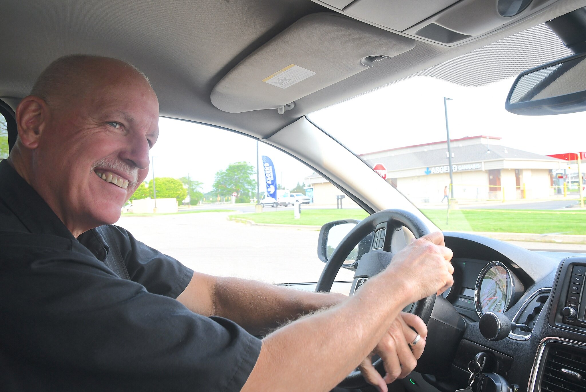 Brian Scott, a driver for BC Transit’s BC-Go, checks traffic as drives to pick up a customer.
