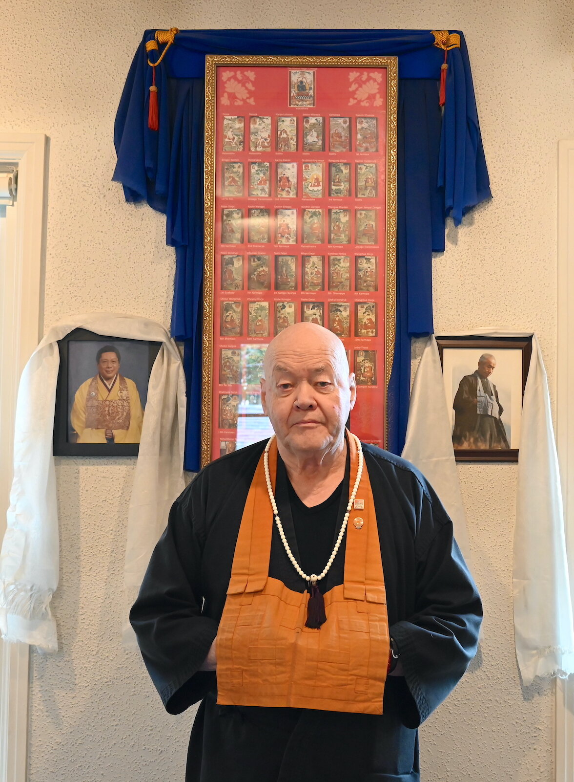 Sokuzan, founding abbot of SokukoJi Buddhist Temple Monastery, stands in front of photos of his teachers, Chögyam Trungpa Rinpoche, left, and Kōbun Chino Otogawa Roshi.