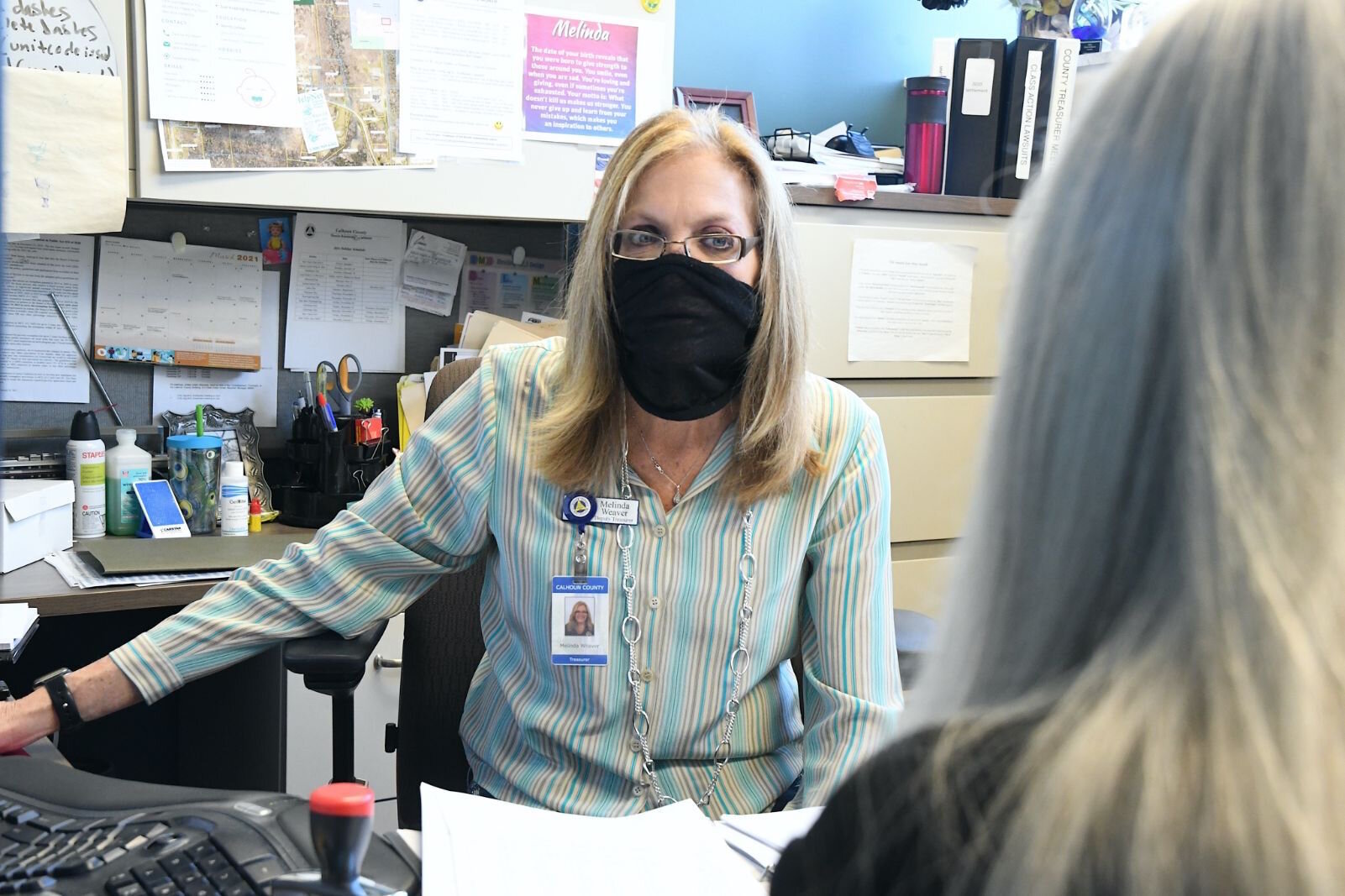 Melinda Weaver, Calhoun County’s Deputy Treasurer, talks with colleagues in the office about property foreclosures.