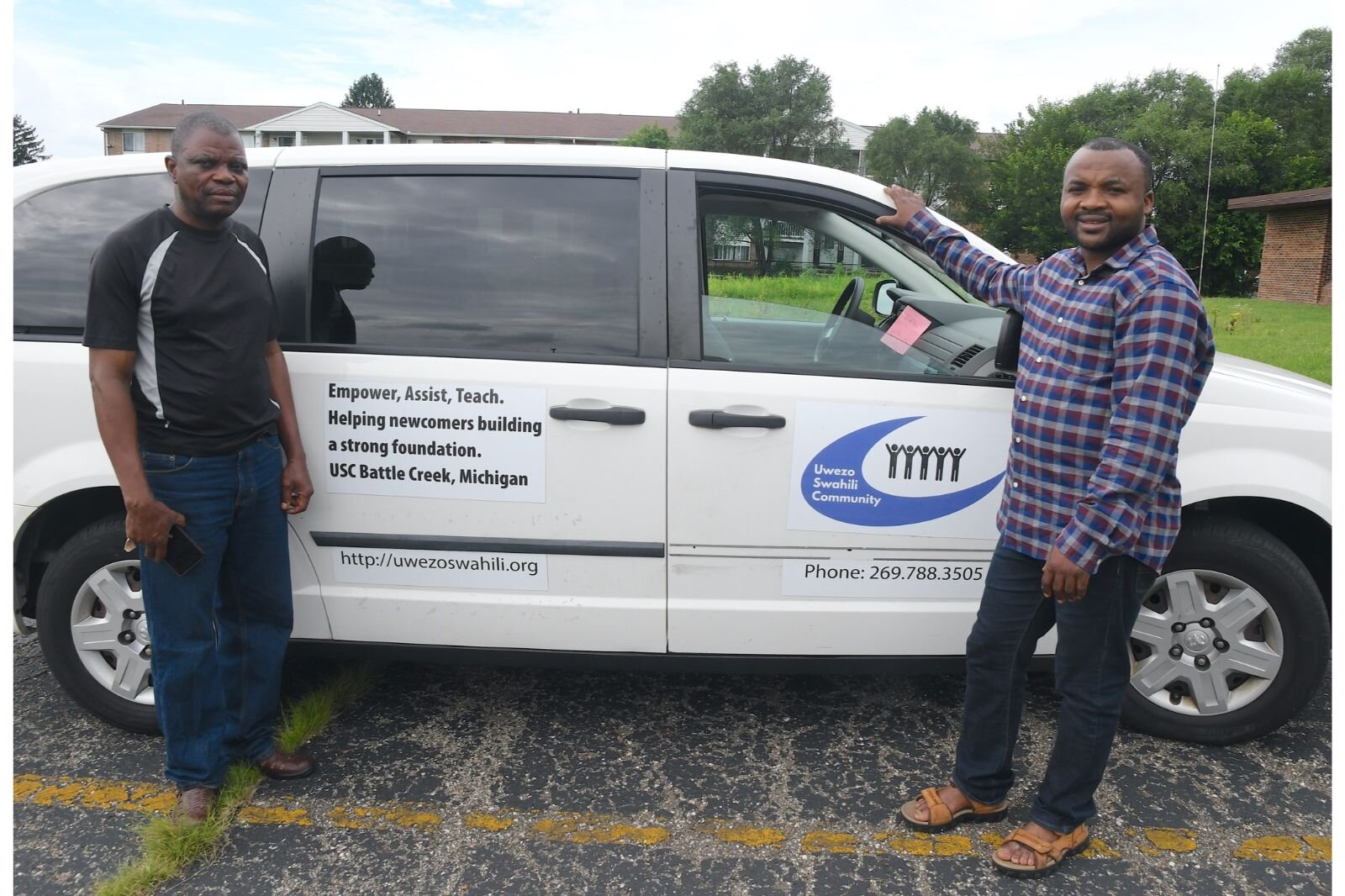 Mbuto Kabumba, left, and Zawadi Kibumba, stand in front of the van used by the Uwezo Swahili Community.