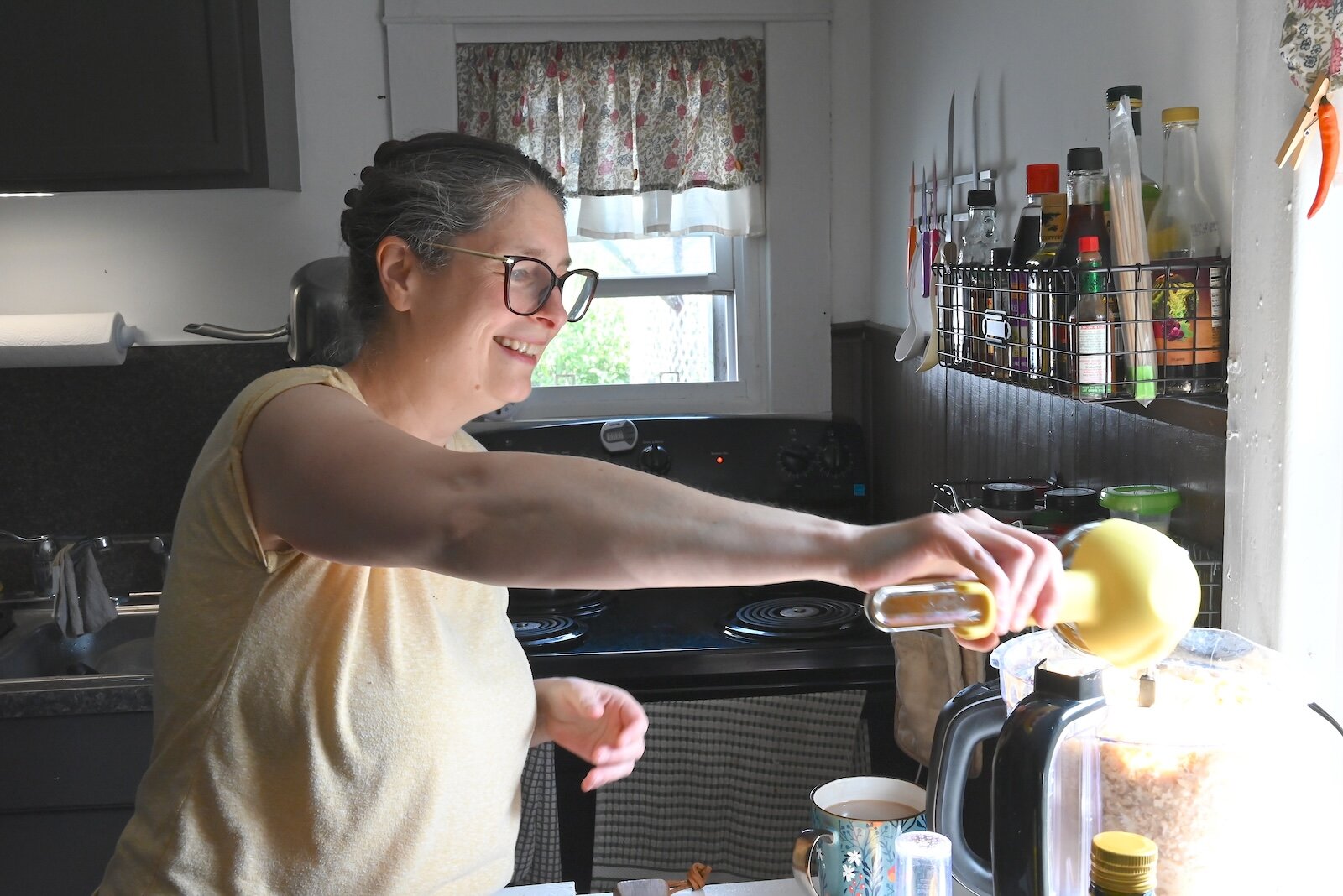 Stacey Kornegay pours lemon juice into the hummus she is making.