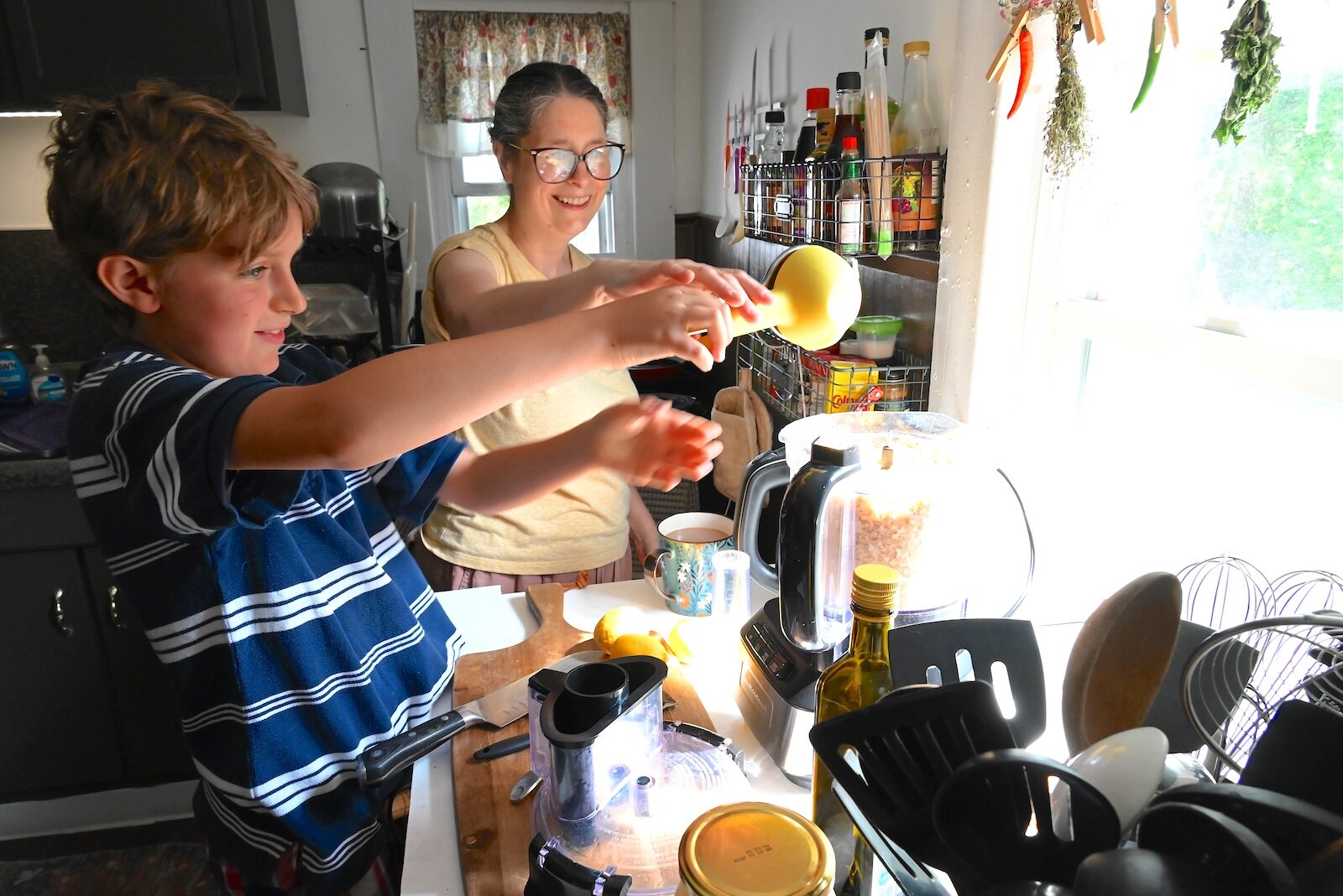 Stacey Kornegay watches her son Liam squeeze lemon juice into the hummus.