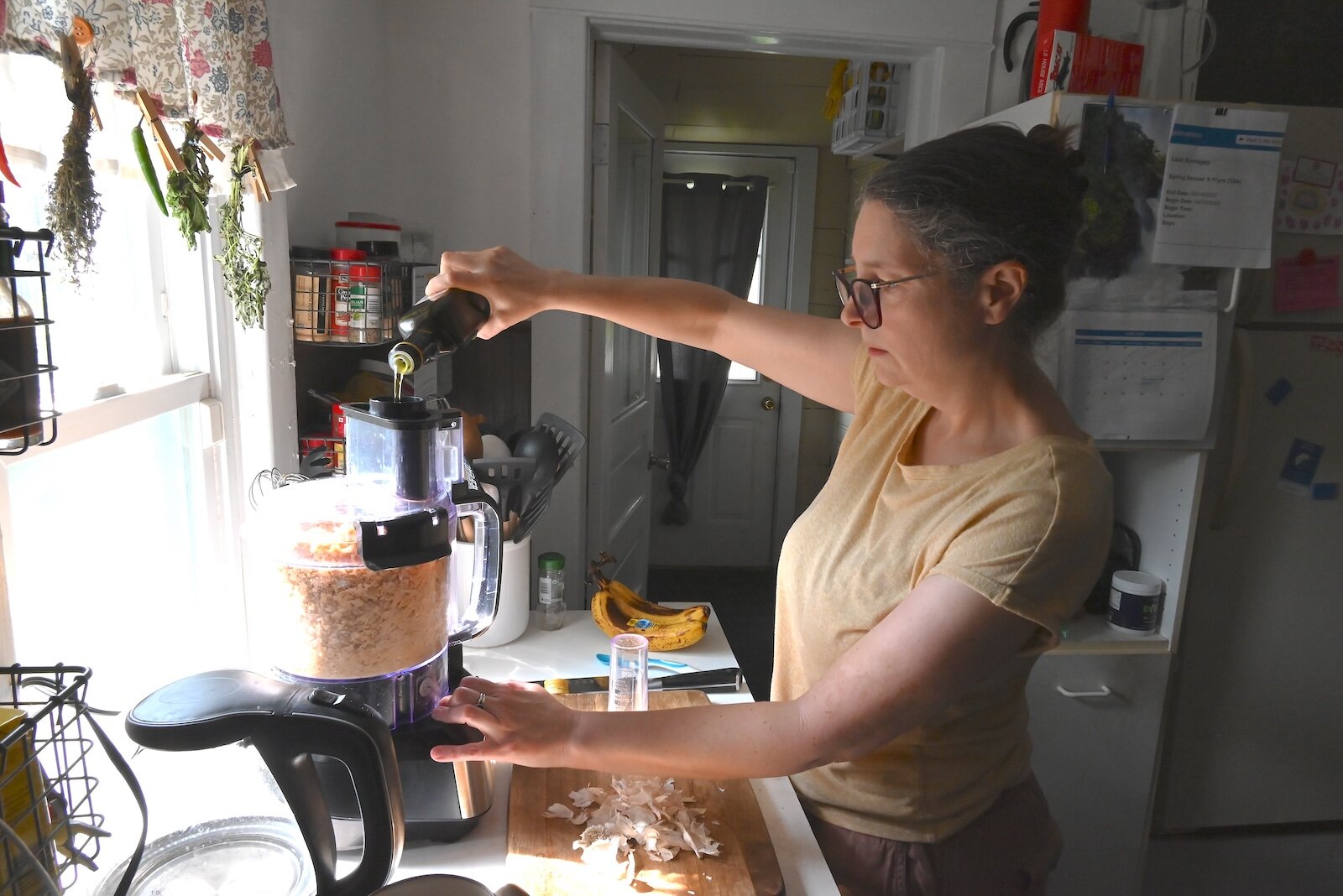 Stacey Kornegay adds olive oil to the hummus she is making.